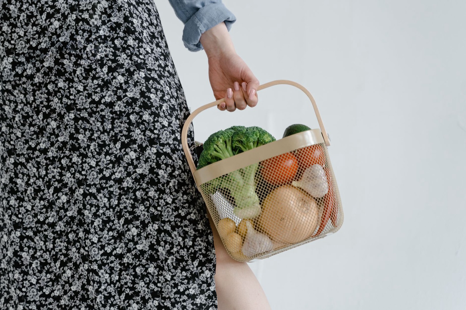Panier de courses avec légumes frais posé sur une table de cuisine